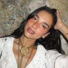 Dua Lipa wearing a pretty white top on vacation in Italy