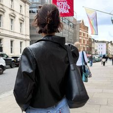 @smythsisters street style shot from the back with claw clip, leather jacket, and black bucket bag