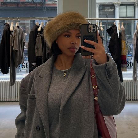 @aysha.sow in a grey crewneck sweater and a blazer coat wearing the faux-fur hat trend