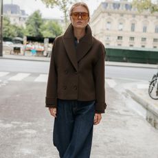 Zara model in brown coat and dark-wash jeans