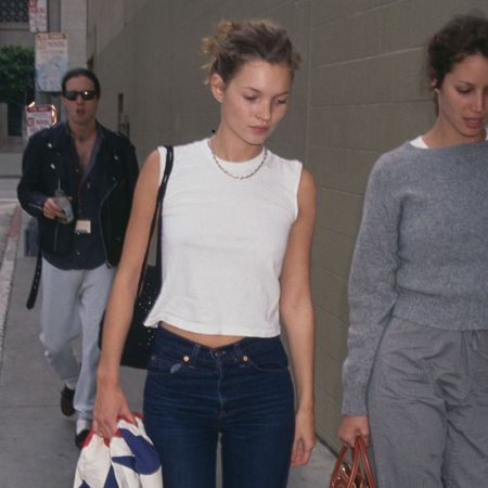 Kate Moss wears cigarette jeans with a white sleeveless top.